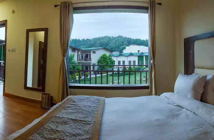 A bed with a window and a view of a lake and buildings